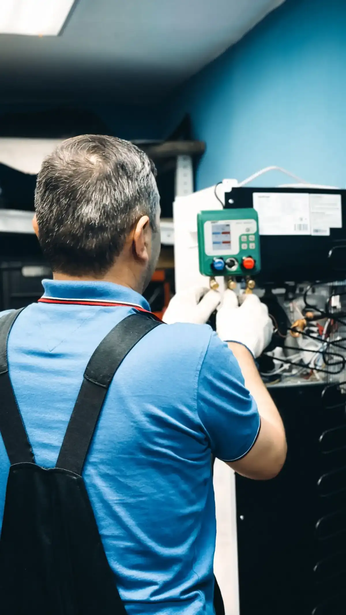 Technician reading refrigerant gauges during AC maintenance