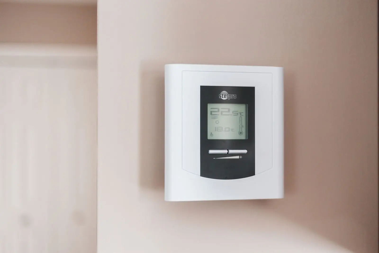 Before: Older basic digital thermostat on a wall